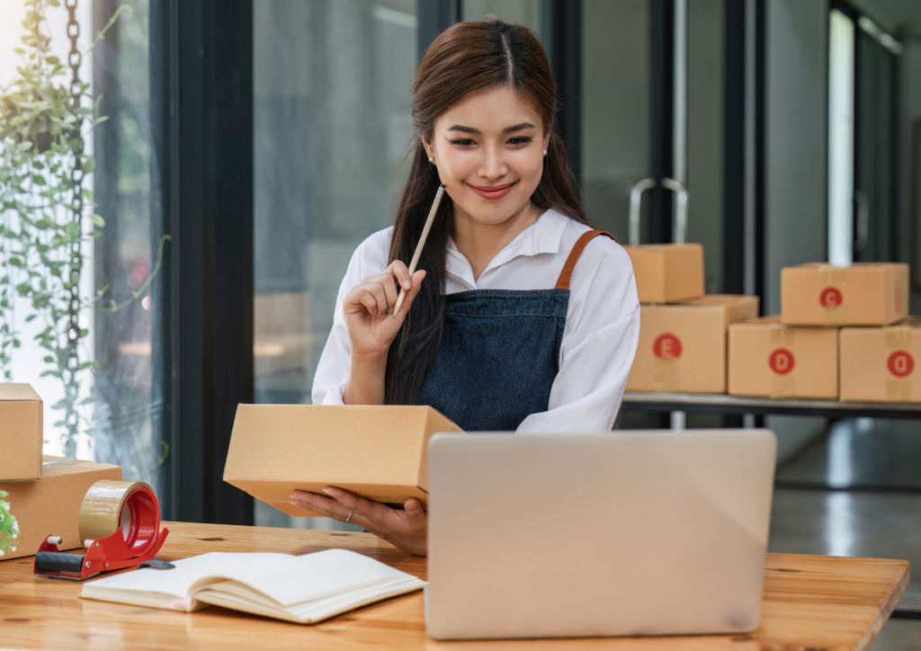 Femme entrepreneuse en train d'expédier des colis depuis son commerce